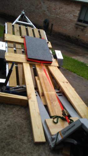 i put some planks of 2x6's to make a ramp and inserted 2x4's under the ramps, then I noticed one of the ramp planks moving so I got a jack underneath to help with support, the pallet jack kept rolling away so i attached a ratchet strap and tightened it. the whole thing felt solid and I removed the bottom retaining plank holding the surface plate on the trailer. As soon as I was ready to start the slide down, it began to rain, I was worried but it actually made the sliding easier and the wood more lubricated.